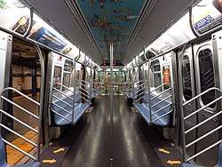 The interior of R160 car 9160, with artwork on the ceiling and at the ends of the car, as well as spreaded-out arrow decals inside the car's doorways