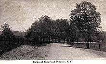 A black and white illustration of an unpaved highway flanked on both sides by fence and trees proceeds through mostly open land. A caption at the bottom reads "Picture of State Road, Patterson, N.Y."