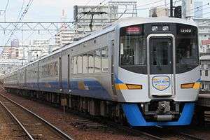 A photo of a Nankai 12000 series train in motion