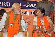 Modi talking to a woman; both are seated.