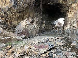 2018 photograph of Needle's Eye Tunnel, near the summit of Rollins Pass. Wire mesh and metal dowels were installed throughout the years to help reduce additional rock falls and preserve the condition of the tunnel constructed in 1903&#032;(115&nbsp;years ago)&#160;(1903).