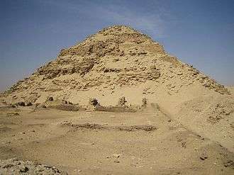 Large but ruined pyramid made of limestone and bricks in the desert.