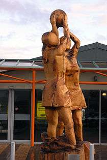 Wooden sculpture of two netball players closely contesting for possession of a netball, at Invercargill Airport in Southland, New Zealand.