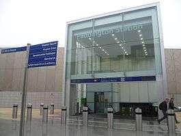A large two-storey entrance with glazed facade. A sign reading "PADDINGTON STATION" is etched into the glass