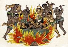 Dark beings throw men with mustaches into a large cauldron with a huge fire underneath it.
