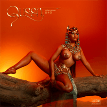 Minaj posing on a fallen tree trunk in front of a setting sun, wearing pasties and Egyptian head beads.