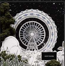 A white Ferris wheel against a night scene, created with paper