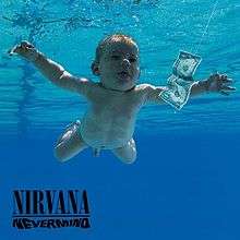 A nude infant swimming in blue tinted water toward a dollar bill which is attached to a string. The band's name and the album title are visible in the lower left corner.