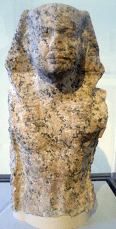 Torso and head of a statue of a king wearing the Egyptian nemes.