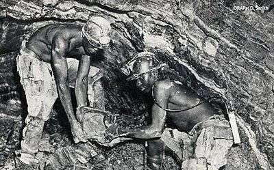 Two miners digging in close quarters