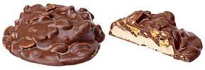 Two views of a candy bar: the left-most whole showing a chocolate covered mound with protruding nuts and the right-most a half showing a nougat base topped with peanuts and both covered in chocolate.