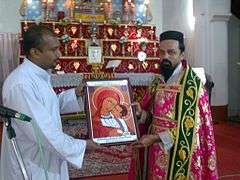Two men holding an icon in front of an altar