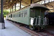 A set of old, green passenger cars