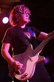 Stipe playing bass guitar onstage