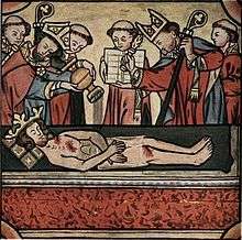 A crowned and bearded dead man lying on a stone is surrounded by two bishops and five monks