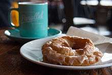 An old-fashioned doughnut with a sugar glaze, accompanied with coffee