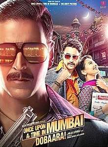 The bust of the title character, Shoaib Khan (Akshay Kumar) wearing black full frame sunglasses consisting the reflection from streetlights dotting the coast line of the city and a black suit and a purple and violet striped shirt underneath holding a gun in his hand occupies a significant portion of the poster, mostly left and lower-front. In this case the city being Mumbai, or Bombay as it was known in the period which the film is set in. The other male lead of the film is facing front wearing a denim jacket, saffron shirt and stylized sunglasses holding his shirt-collar up with a woman breaking into laughter resting on his chest looking upwards. The backdrop consists of verandahs of chawls of Mumbai and a waxing crescent moon in the sky. The title logo of the film and credits below.