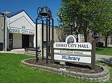 Sign and entrance for Osseo City Hall and Library in front of a plain, one-story building