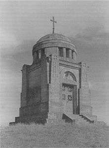 The Ostrach battle monument is a small, square building, raised from the ground about .5 meter, 8 meters high. A 3&nbsp;meter dome, topped with a simple cross, caps the monument. It is of marble, with a simple double door.