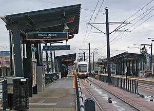 Light rail vehicle approaches ground-level station platform
