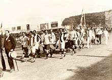 Photograph of men carrying a banner
