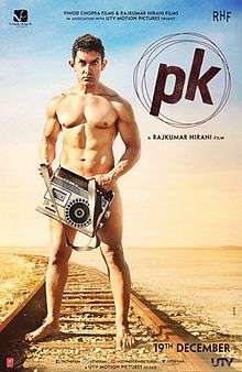 Khan, as the title character PK, stands nude on railroad tracks, looking into the camera while obscuring his genitals with a cassette tape player.