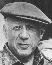 An elderly Pablo Picasso in a cloth cap, grinning at the camera