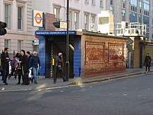 A narrow single-storey tiled building with a London Underground roundel above a sign reading "Paddington Underground Station"