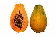 Photograph showing a papaya in cross section, with orange flesh and numerous black seeds