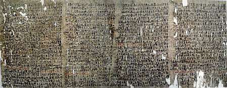 Large papyrus full of cursive inscriptions in black and occasional red ink, riddled with small holes.