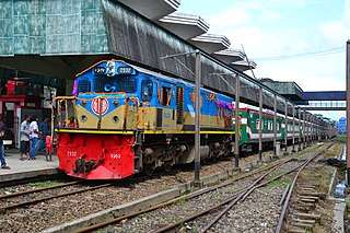 Green passenger train pulled by a blue diesel engine