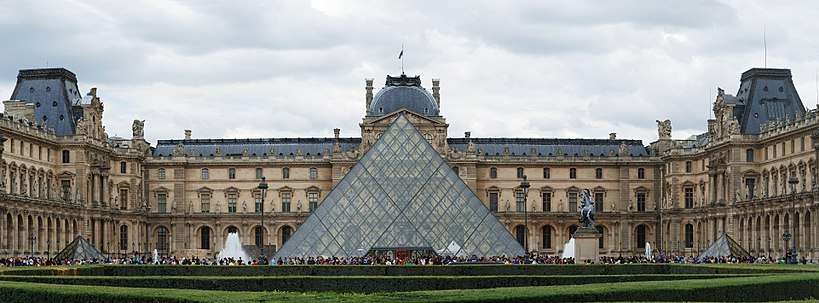 The The Louvre Museum at night with the large glass pyramid.