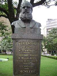 A bronze bust of a bearded man sits atop a plinth inscribed with a dedicatory inscription for the Centenario de D. Pedro the second