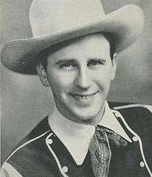 A smiling man wearing a cowboy hat