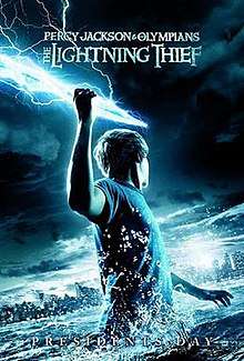 A youth, standing in a large body of water in the dark, holds a bolt of lightning in his raised right arm and faces away, towards a city skyline