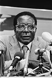 Robert Mugabe, surrounded by microphones