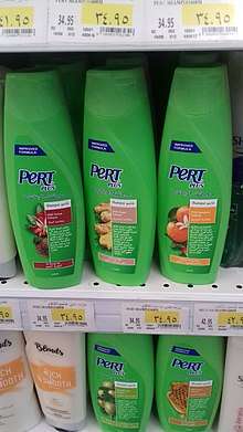 Green plastic bottles of Pert Plus shampoo displayed on shelves in a store in Cairo, Egypt