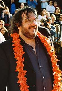 Peter Jackson looks away from the camera and has a garland over his neck.