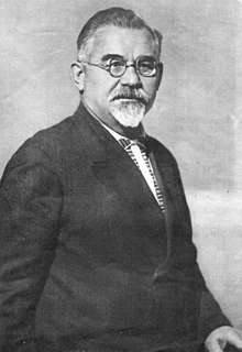 Photo of a man with round glasses and a goatee