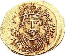 A gold coin with the bust of Phocas. His eyes form the central focus of the image