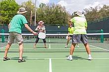 A doubles game of pickle ball.