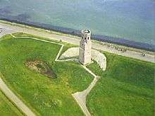 Aerial photograph of a white stone tower near the shore