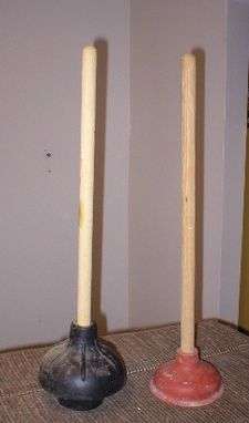2 upright plungers, left one black with extension, right one red.