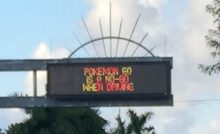 A variable-message sign over a road that reads "Pokémon Go is a no-go when driving".