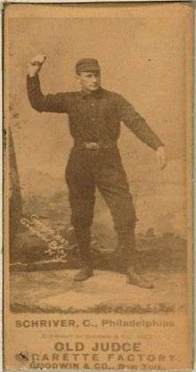 A sepia-toned blurry image of a man wearing an old-style dark-colored baseball uniform