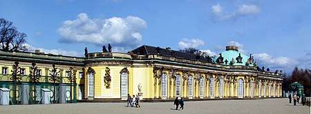 Single story pale yellow ornate palace stretching from the left foreground to the right background.