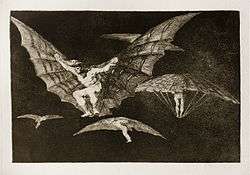 Four or five men fly with contraptions resembling bat's wings attached to their arms.