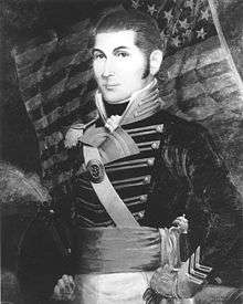 portrait of O'Bannon standing in a dress uniform with a U.S. flag in the background