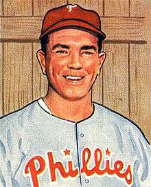 A baseball card image of a smiling man wearing a red baseball cap and a gray baseball jersey with "Phillies" across the chest in red script