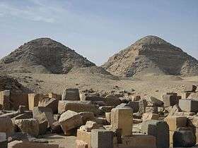 Photograph of two pyramids at Abusir. On the left, the shorter ruined Pyramid of Nyuserre. On the right, the taller pyramid of Neferirkare.